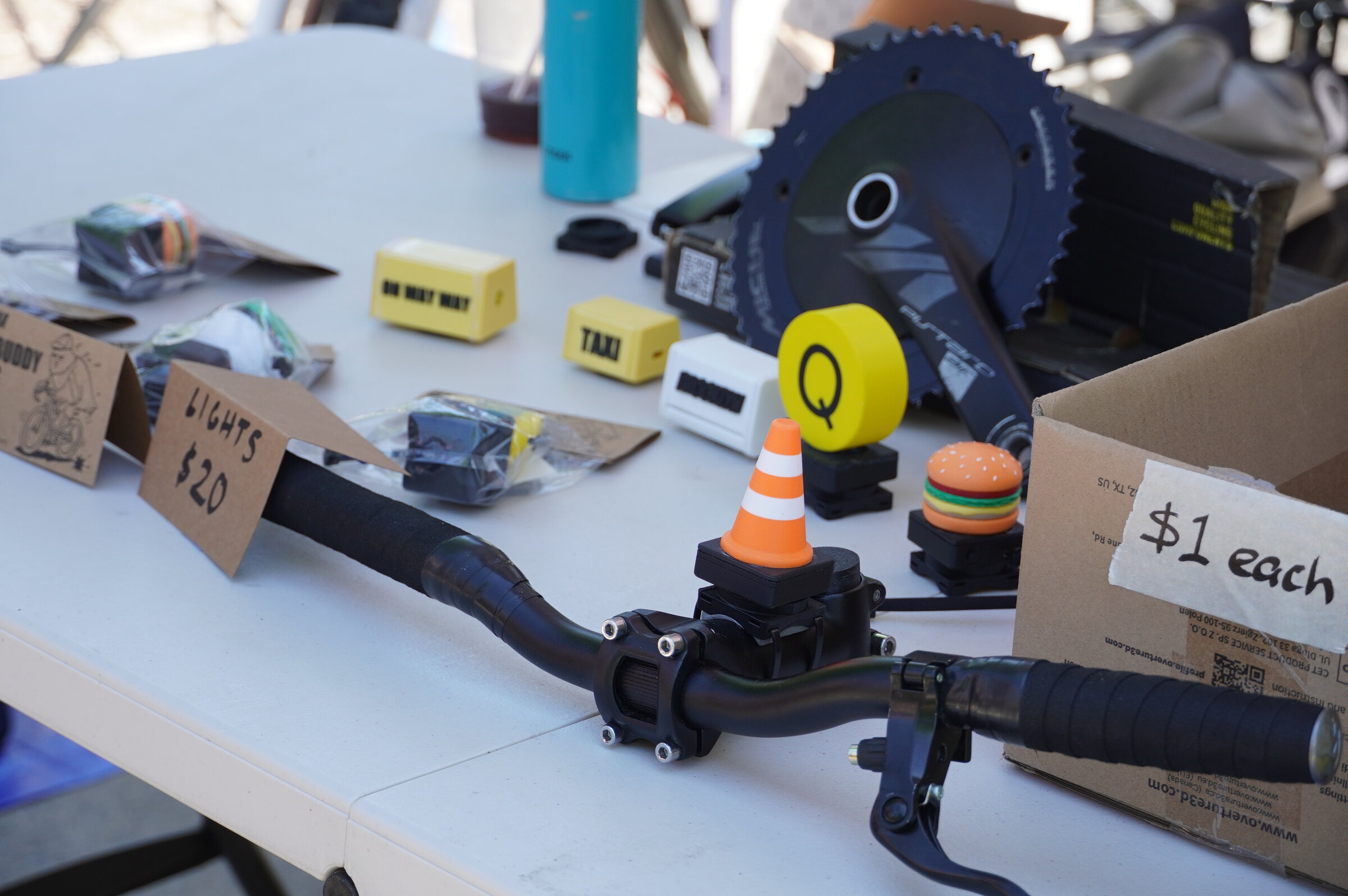 Bike Buddy lights mounted to a bike handlebar at the STEMMA market table